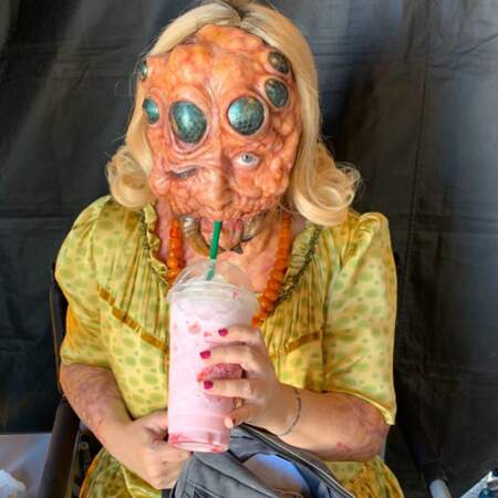 Lucy Davis est contente : son (affreux) masque de monstre lui permet quand même de boire son milkshake, ouf !